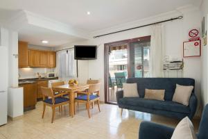 ein Wohnzimmer mit einer blauen Couch und einem Tisch in der Unterkunft Apartamento Pedro in Puerto de Mogán