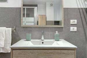ein Badezimmer mit Waschbecken und Spiegel in der Unterkunft Apartamento Pedro in Puerto de Mogán + 12 Fotos