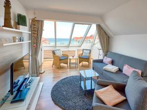 a living room with a couch and a table at Apartmenthaus Jahreszeiten - Meerblick-Fewo 28 in Binz