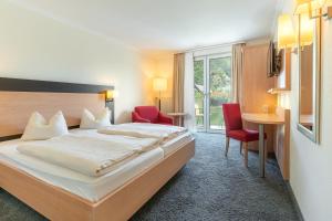 ein Hotelzimmer mit Bett, Tisch und Stühlen in der Unterkunft Hotel Restaurant Pollmanns in Ernst