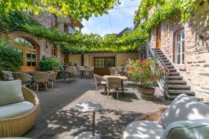 an outdoor patio with tables and chairs and vines at Hotel Restaurant Pollmanns in Ernst