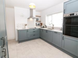 a kitchen with blue cabinets and a sink at Angorfa in Pwllheli