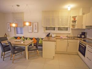 una cucina e una sala da pranzo con tavolo e sedie di Casa Sellin - Apt. 02 a Ostseebad Sellin