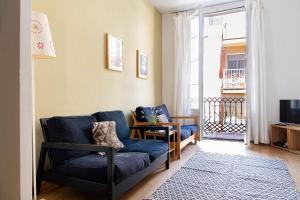 a living room with a blue couch and a television at Amplio con dos dormitorios en Sant Antoni / Poble Sec in Barcelona