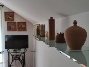 uma sala de estar com um balcão de vidro com vasos em Apartments Leni em Postojna