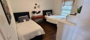 een kleine slaapkamer met twee bedden en een raam bij Blue Fish Cottage in Waterford