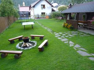 un patio trasero con mesas de picnic y una hoguera en Dovolenkový dom Dudáš, en Oravský Biely Potok
