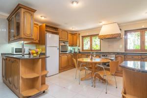 a kitchen with a table and a white refrigerator at Es Moli dels Reis in Son Sardina