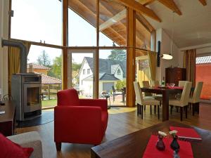 sala de estar con silla roja y mesa en Ferienhaus Luv & Lee - Apt. 01, en Ostseebad Sellin