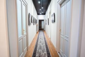 a hallway with white doors and a rug at The Host in Parma