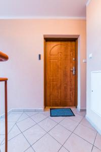 a wooden door in a room with a tile floor at Belweder Diamentowy in Olsztyn