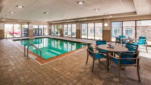 una piscina con mesa y sillas y un asterisco en Best Western Plus Champaign/Urbana Inn, en Champaign