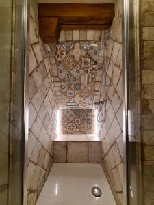 a bathroom with a shower with a tile wall at Am Waldessaum in Kurort Oybin