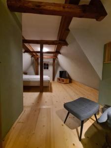 a attic room with a bed and a blue stool at Am Waldessaum in Oybin