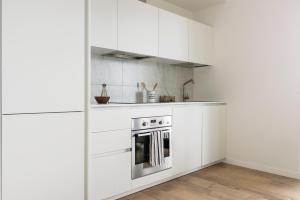 a kitchen with white cabinets and a stove at ALTDIO UpTown Flats with Balcony, Good Connection to Milan Centre in Milan