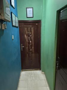 a brown door in a room with green walls at NUMBERS FLIPPERS SERVICES Apartment in Ikeja