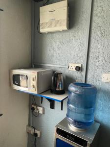 a microwave and a toaster oven on a shelf at NUMBERS FLIPPERS SERVICES Apartment in Ikeja