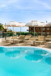 een groot zwembad met stoelen en parasols bij Hotel Arena in Sirmione