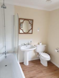 a bathroom with a sink and a toilet and a mirror at Lochs Lodge, Glenlyon, Perthshire 