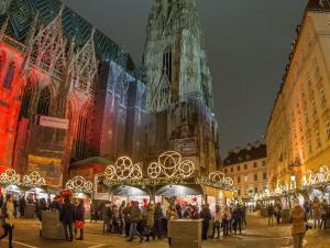 een groep mensen die rond een kerstmarkt voor een kathedraal staan bij Oskar Kokoschka - City Apartment Downtown Vienna in Wenen