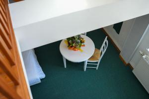 - une vue de tête sur une table et des chaises avec un bol de fleurs dans l'établissement Hôtel Picardia, à Saint-Valery-sur-Somme