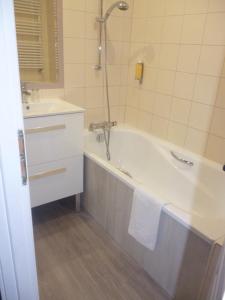 y baño con bañera y lavamanos. en Hôtel Picardia en Saint-Valery-sur-Somme