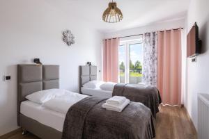 sypialnia z 2 łóżkami i oknem w obiekcie Apartamenty EverySky Górskie Tarasy - Kwiatowa 7 w mieście Karpacz