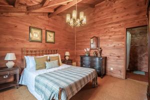 a bedroom with a bed and a wooden wall at Villa Achada da Mouca by Madeira Sun Travel in Santana