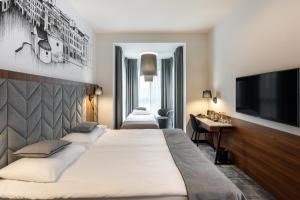 ein Hotelzimmer mit einem Bett und einem Flachbild-TV in der Unterkunft Garden Square Hotel in Krakau