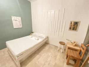 a small bedroom with a bed and a wooden chair at Pallet Homes - Tabuc Suba in Iloilo City