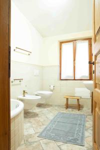 Baño blanco con 2 lavabos y 2 aseos en Casa Pilighitta, en Dorgali