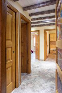 pasillo con puertas de madera y habitación con cama en Casa Pilighitta, en Dorgali