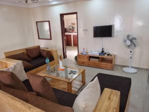 a living room with a couch and a tv at CHAMBRES PRIVEES CLIMATISEES-DOUCHES PERSONNELLES-NEFLIX-SALON in Dakar