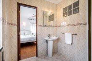 a bathroom with a sink and a mirror at Carepa SUITES in Nazaré