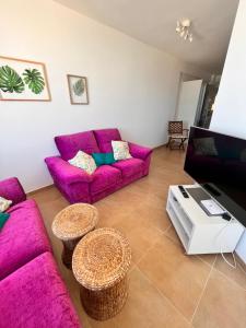 a living room with purple couches and a table at Precioso apartamento en 5 minutos de la playa in Playa de las Americas