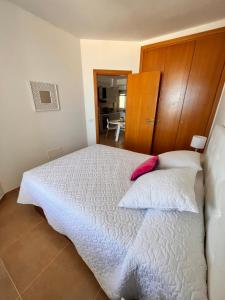 Un dormitorio con una cama blanca con cabecero de madera. en Precioso apartamento en 5 minutos de la playa, en Playa de las Américas 13 fotos más
