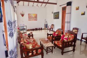a living room with chairs and a couch and a table at Rodrigo's Villa & Restaurant in Negombo