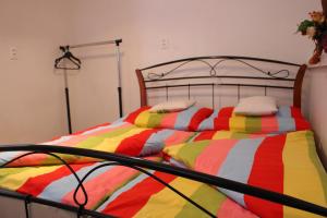 a bed with a colorful striped comforter in a room at Ubytovanie u Vlada in Medzilaborce