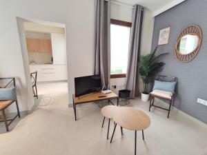 a living room with a table and chairs and a tv at Alojamiento San Basilio Suite in Córdoba