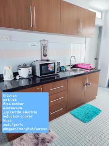 una cucina con forno a microonde e lavandino di SugarStay Homestay Teluk Kemang a Port Dickson