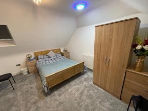 una camera con letto e armadio in legno di Cheerful 4 Bedroom luxury house with free parking a Quinton
