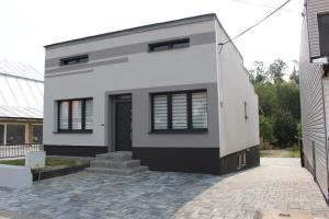 una casa blanca con una fachada en blanco y negro en Ubytovanie u Vlada, en Medzilaborce