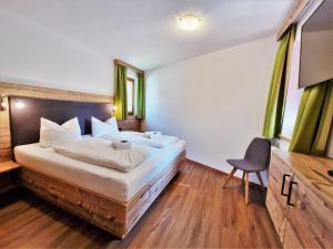 ゲルロスにあるFerienhaus Berghofのベッドと椅子付きのホテルルーム