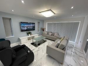 a living room with a couch and a tv at Cheerful 4 Bedroom luxury house with free parking in Quinton