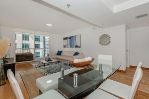 sala de estar con mesa y sofá en Lovely condo with city & ocean views. Sleep up to 6 people!, en Miami