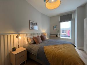 una camera con letto, lampada e finestra di Sutcliffe House a Dublino