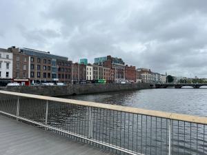 a river in a city with buildings and a bridge at Sutcliffe House in Dublin