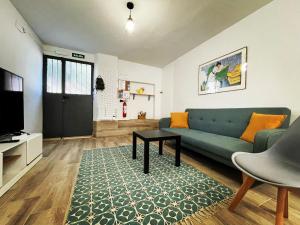 ein Wohnzimmer mit einem Sofa und einem Tisch in der Unterkunft Apartamento “El Cauce” en Sierra de Gredos - La Vera - WIFI in Madrigal de la Vera