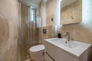 łazienka z umywalką, toaletą i prysznicem w obiekcie SPACIEUX STUDIO HAUT PLAFOND PROCHE MONACO w mieście Beausoleil +7 zdjęć