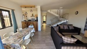 a living room with a long table and a staircase at Coquette villa avec piscine in Flic-en-Flac